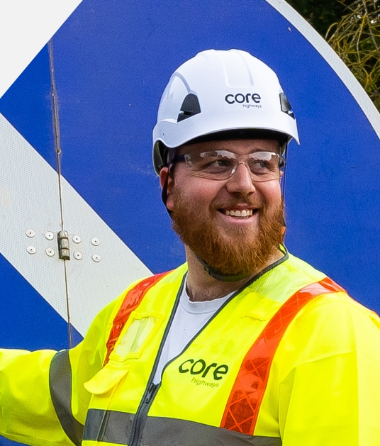 smiling core highways team member in high visibility jacket and hart hat